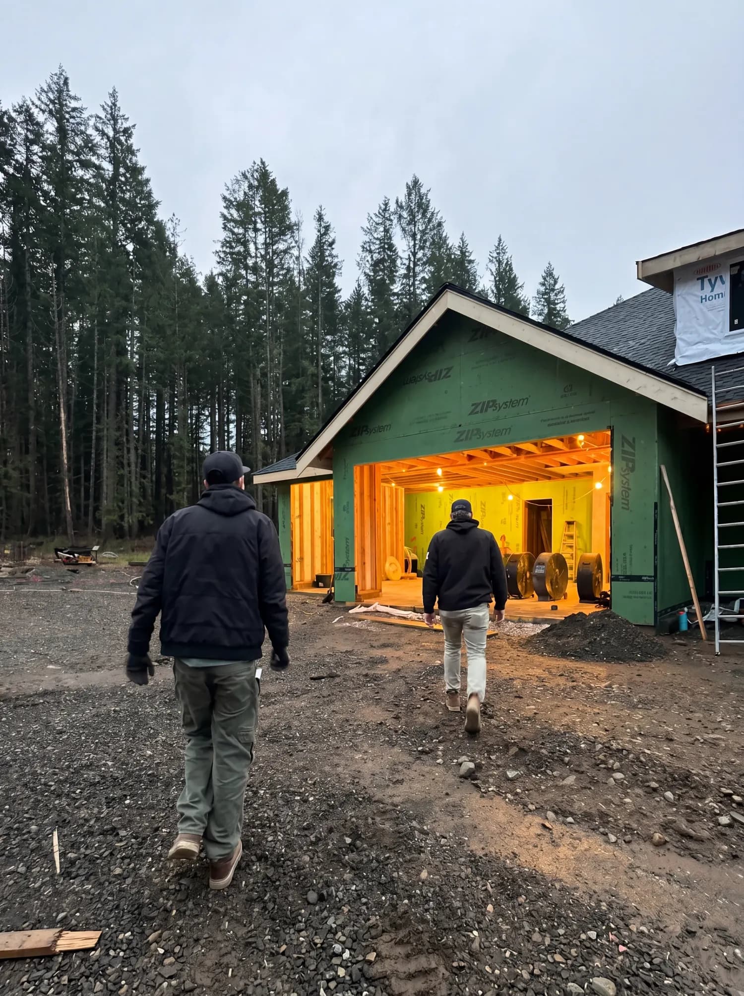 Two Valor Plumbing crew members walking up to a new construction home